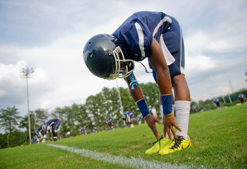 Cedar Grove's Demarques Dunson stretches with his teammates before their game against Tucker at Panthersville Stadium in Decatur on Friday, August 23, 2013.   