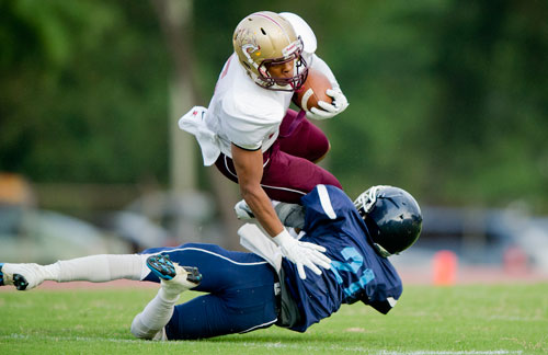 Tucker's Devin Towns (left) is tackled by Cedar Grove's D'Angelo Pinkett during their game at Panthersville Stadium in Decatur on Friday, August 23, 2013.