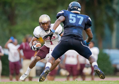 Tucker's Dominick Sanders (1) runs straight towards Cedar Grove's Keenan Kelly (57) during their game at Panthersville Stadium in Decatur on Friday, August 23, 2013.