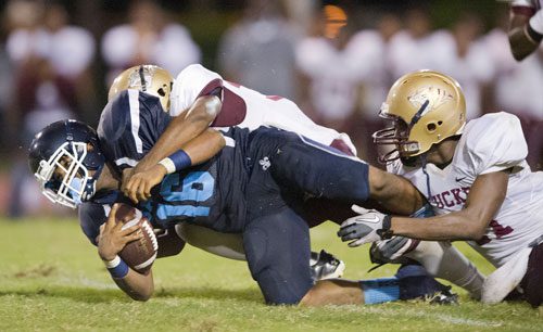 Cedar Grove's Deion Seller (16) is tackled by Tucker's Nekyle Lundie (right) and Tommy Renfroe during their game at Panthersville Stadium in Decatur on Friday, August 23, 2013. 