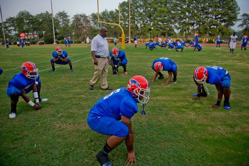 Columbia's Montrez Johnson (5) stretches with his teammates as linebacker coach Antonio Moore paces around the circle before their game against Cedar Grove at Panthersville Stadium in Decatur on Friday, August 30, 2013.