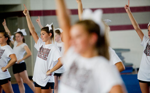 Sydney Greer (left) performs different cheers with her squad during cheerleading practice at Northgate High School in Newnan on Tuesday, August 20, 2013. 