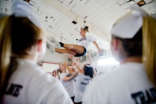 Natalie Dyer (center) is protected by her squad as she comes down from a stunt during cheerleading practice at Northgate High School in Newnan on Tuesday, August 20, 2013. 