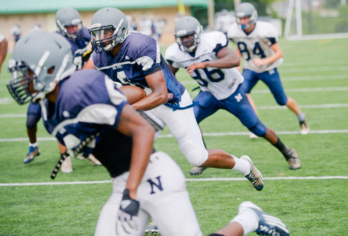 Norcross' A.J. Bush (center) runs a play during practice on Wednesday, August 21, 2013. 