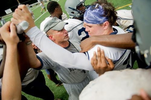 Norcross defensive line backercoach Pat Standard (left) stands in a huddle with Warren McWilliams (right) and other players during practice on Wednesday, August 21, 2013. 