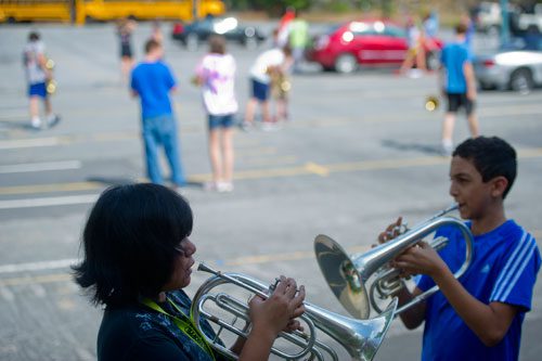 Natasya Tamba (left) and Anas Alhabbal warm up on their mellophones before marching band practice at Centennial High School in Roswell on Thursday, August 22, 2013.