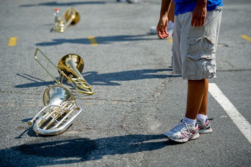 Instruments lay on the pavement as students in the Centennial High School marching band stretch before practice on Thursday, August 22, 2013.
