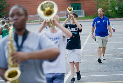 Band director Michael Reid counts as his students march through the parking lot during marching band pratice at Centennial High School in Roswell on Thursday, August 22, 2013.