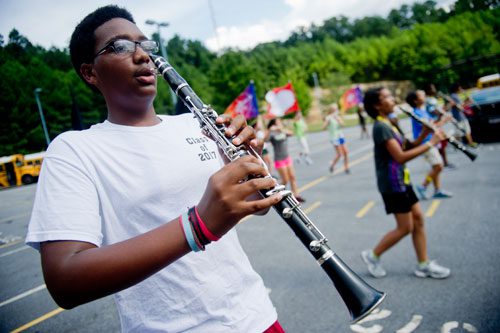 Keyshaun Scott holds his clarinet in front of his face as he participates in drills during marching band practice at Centennial High School in Roswell on Thursday, August 22, 2013.
