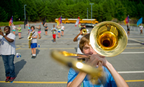 Andrew Peterson (right) holds his trombone in front of his face as he participates in drills during marching band practice at Centennial High School in Roswell on Thursday, August 22, 2013.