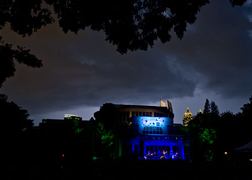 Lightning flashes in the sky over Atlanta as Boz Scaggs performs on stage at the Atlanta Botanical Gardens on Friday, July 19, 2013.