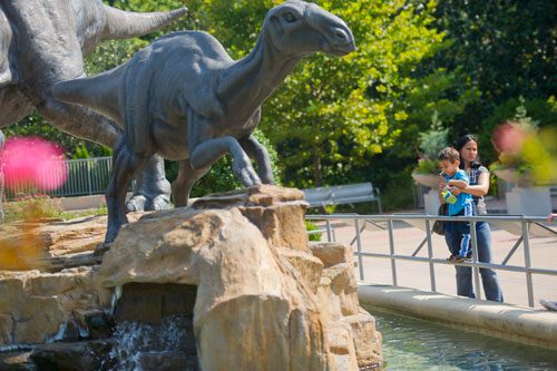 Kat Cooper holds her son Anders as he checks out one of the dinosaurs in front of the Fernbank Museum of Natural History in Atlanta on Saturday, August 24, 2013.