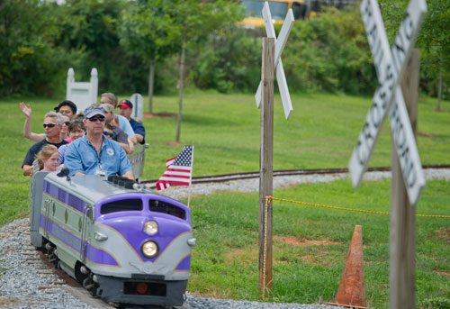 Mark Sutcliffe (center) conducts a train ride on the old Birmingham Zoo Wisconsin 1956 train during Trains, Trucks and Tractors at the Southeastern Railway Museum in Duluth on Saturday, August 3, 2013.