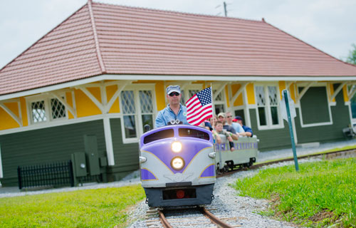 Mark Sutcliffe (center) conducts a train ride on the old Birmingham Zoo Wisconsin 1956 train during Trains, Trucks and Tractors at the Southeastern Railway Museum in Duluth on Saturday, August 3, 2013. 