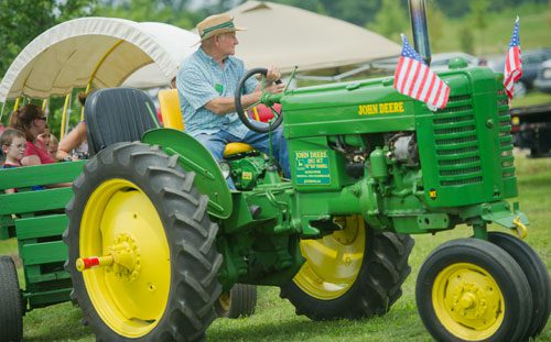 Kim Kimbrell drives a tractor as he conducts hayrides during Trains, Trucks and Tractors at the Southeastern Railway Museum in Duluth on Saturday, August 3, 2013.