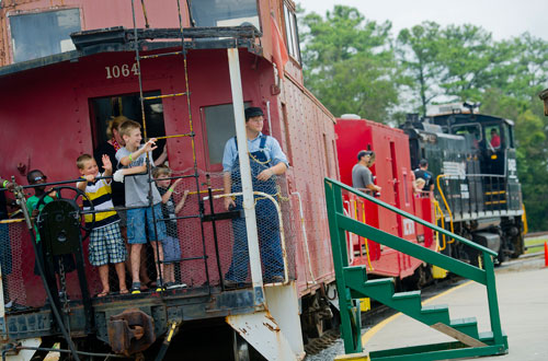 Nicholas Johnson (left), Harrison Gumbert, Chris Thompson, Bailey Janssen and Sam Rehonic stand on the end of a caboose as they take a train ride during Trains, Trucks and Tractors at the Southeastern Railway Museum in Duluth on Saturday, August 3, 2013. 