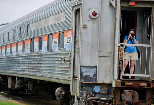 Emily Novick takes a photograph from the back of an Amtrak sleeper car during Trains, Trucks and Tractors at the Southeastern Railway Museum in Duluth on Saturday, August 3, 2013.