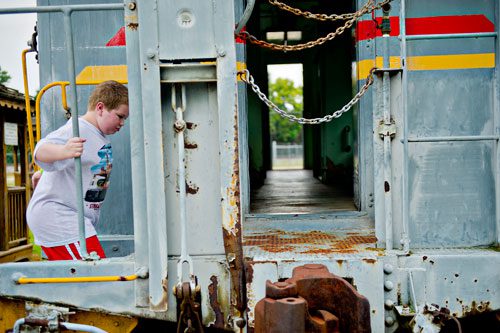 Sam Dworkin climbs aboard a train car during Trains, Trucks and Tractors at the Southeastern Railway Museum in Duluth on Saturday, August 3, 2013. 