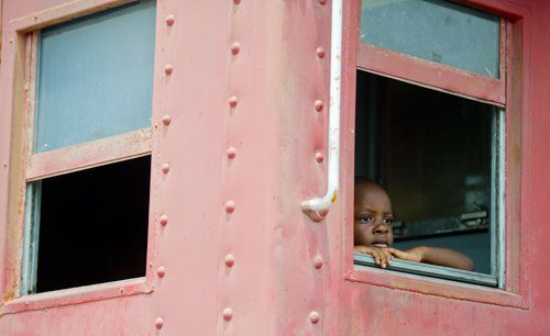 Sebastian Mitchell peers out of the window of a caboose as he takes a train ride during Trains, Trucks and Tractors at the Southeastern Railway Museum in Duluth on Saturday, August 3, 2013. 
