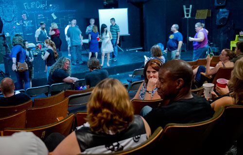 Jon Carr (right) and Allie Southwood talk as they sit in the audience seats at Dad's Garage in Atlanta during the Bringing Down the House Party on Saturday, August 3, 2013. 