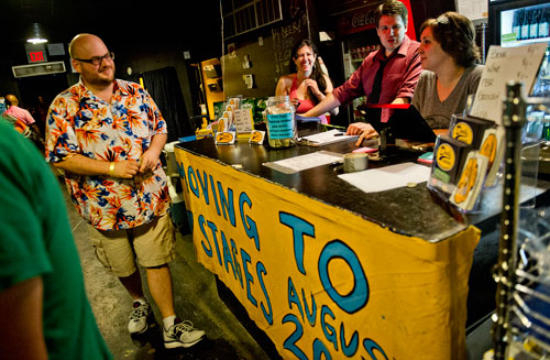 Courtney Greever (right), August Pollak and Liz Grofic tend bar as Jonathan Shroyer walks through the line during the Bringing Down the House Party at Dad's Garage in Atlanta on Saturday, August 3, 2013.