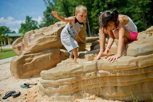 Sophie Haney and her brother Nolan play in a part of the archeological dig site at the playground at Caney Creek Preserve in Cumming on Friday, August 9, 2013.