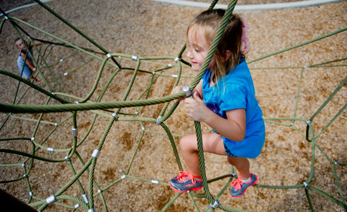 Kensley Burke (right) and Nolan Haney climb on the playground at Caney Creek Preserve in Cumming on Friday, August 9, 2013.