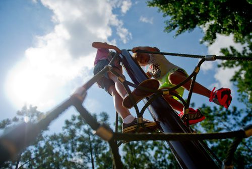 Megan Bunker (left) and Riley Burke climb on the playground at Caney Creek Preserve in Cumming on Friday, August 9, 2013.