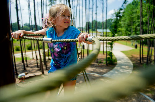 Kensley Burke climbs on the playground at Caney Creek Preserve in Cumming on Friday, August 9, 2013. 