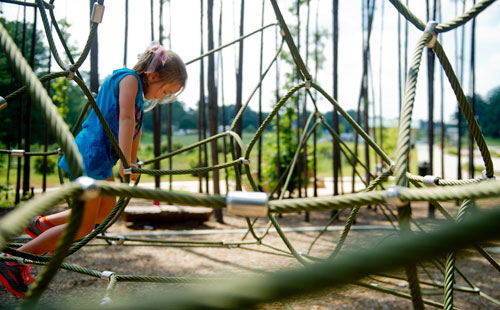 Kensley Burke climbs on the playground at Caney Creek Preserve in Cumming on Friday, August 9, 2013.