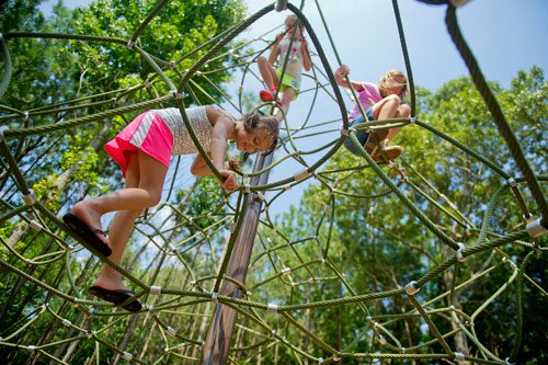 Sophie Haney (left), Riley Burke and Megan Bunker climb on the playground at Caney Creek Preserve in Cumming on Friday, August 9, 2013.