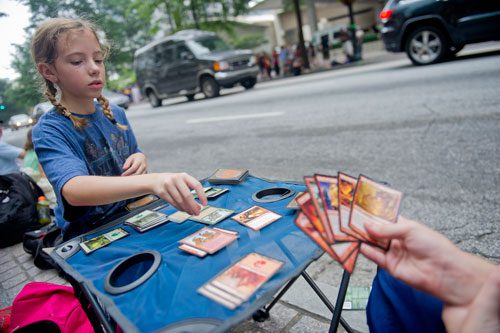 Fiona Burnett (left) plays a game of Magic with her brother as they wait for the start of the annual DragonCon parade through downtown Atlanta on Saturday, August 31, 2013. 