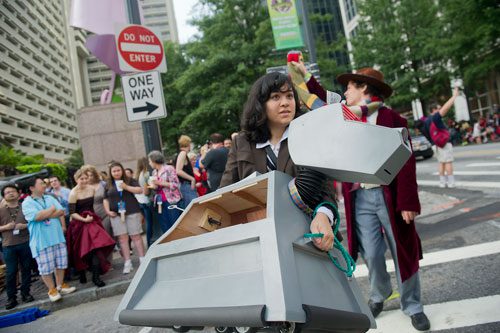Rachel Burdge (center) carries her robot k-9 across Baker Street as she heads to the staging area for the annual DragonCon parade through downtown Atlanta on Saturday, August 31, 2013. 