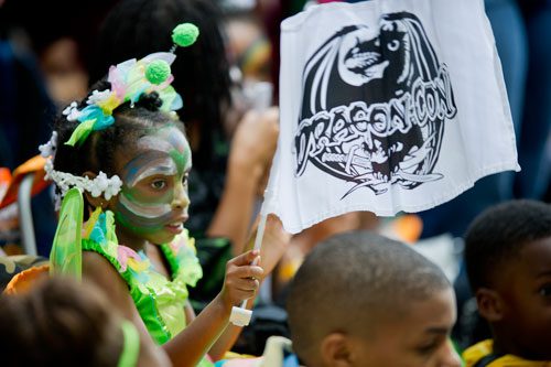 De'Andra Roberts waves a DragonCon flag as she watches the annual parade pass through downtown Atlanta on Saturday, August 31, 2013.