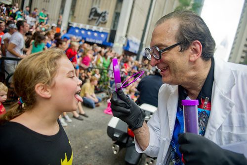 Alan Russell Koslow (right) uses a magnifying glass to examine Brooklyn Wucher as he marches in the annual DragonCon parade through downtown Atlanta on Saturday, August 31, 2013.