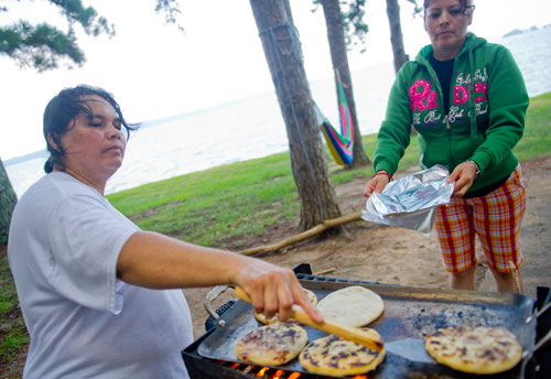 Rosa Bonilla (left) cooks pupusas with the help of Maria Castro at Van Pugh Park on the shore of Lake Lanier in Flowery Branch on Sunday, September 1, 2013. 
