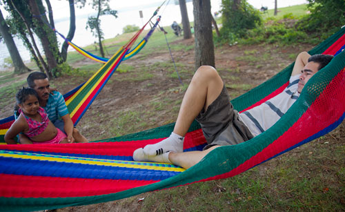 Jose Costanza (right), Oscar Bonilla and his daughter Emily relax in a set of hammocks at Van Pugh Park on the shore of Lake Lanier in Flowery Branch on Sunday, September 1, 2013. 