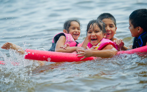 Michelle Hernandez (left), Isabella Campos, Nicholas Campos and Rodrigo Hernandez swim in Lake Lanier at Van Pugh Park in Flowery Branch on Sunday, September 1, 2013.