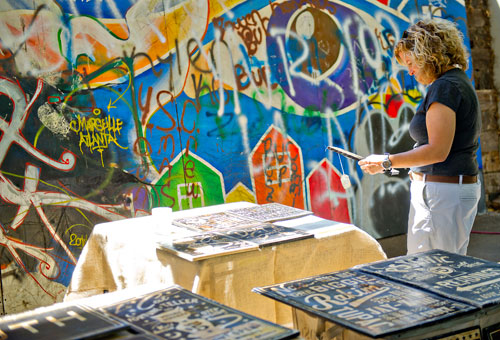 Tracey Long looks at artwork designed by George Hanna during the Reynoldstown Wheelbarrow Festival at Lang Carson Park in Atlanta on Saturday, September 14, 2013.