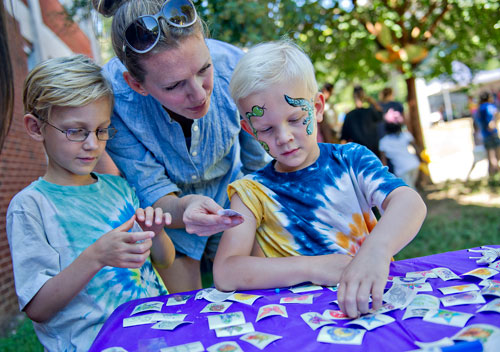 Jack Leerssen (right) and his brother James (left) have their mother Christina help apply temporary tattoos during the Reynoldstown Wheelbarrow Festival at Lang Carson Park in Atlanta on Saturday, September 14, 2013. 