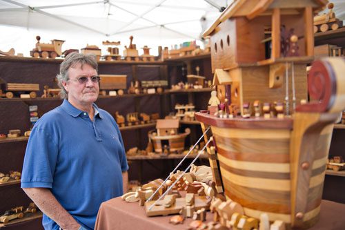 Lee McDonald looks at the wooden ark on display in Jim Newbury's booth during the Atlanta Arts Festival at Piedmont Park on Sunday, September 15, 2013. 