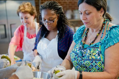 Lucia Smeal (right), Morgan Dooley and Martha McMillin cut up pears during a canning class at The Preserving Place in Atlanta on Saturday, September 14, 2013. 
