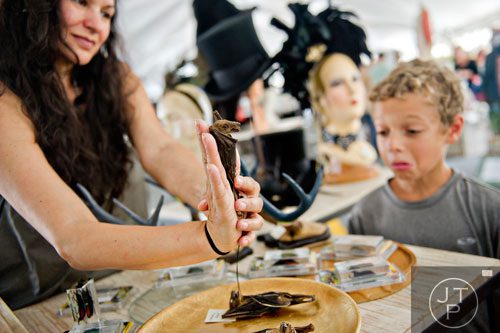Diana Adelberg (left) shows Aiden Spies a taxidermied bat during the European Market on Milton Street in Alpharetta on Sunday, September 22, 2013. 