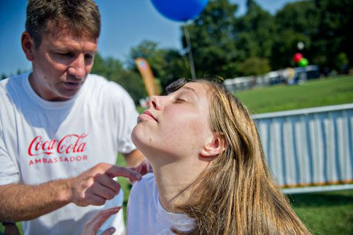 Stacey Oglesby (right) balances an oreo cookie on her forehead as Vic Stephens gives advice on how to get it to her mouth without using her hands during the Boys & Girls Clubs of America's Day for Kids at Piedmont Park in Atlanta on Saturday, September 7, 2013.