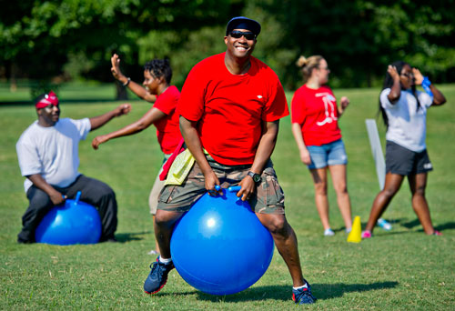 Neil Chester (center) bounces on a ball while participating in a relay race during the Boys & Girls Clubs of America's Day for Kids at Piedmont Park in Atlanta on Saturday, September 7, 2013. 