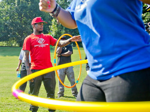 R&B artist Ne-Yo (left) competes in a hula hoop contest during the Boys & Girls Clubs of America's Day for Kids at Piedmont Park in Atlanta on Saturday, September 7, 2013. 