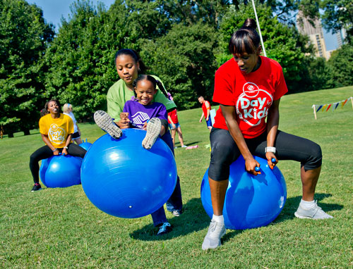 Jackie Joyner-Kersee (right) bounces on a ball as she races Legacy Devers, Mallory Hammett and Gail Devers during the Boys & Girls Clubs of America's Day for Kids at Piedmont Park in Atlanta on Saturday, September 7, 2013. 