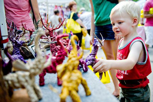 Vaughn Seely looks at the animals on display at the Jute Sculptures booth during the Yellow Daisy Festival at Stone Mountain Park on Saturday, September 7, 2013. 