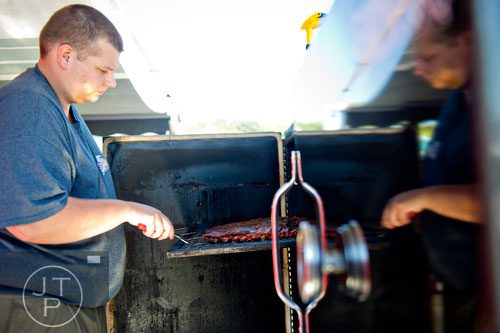 Jonathan Timmons with the Hogz Gone Wild team checks a rack of spare ribs during the Atlanta Bar-B-Q Festival at Atlantic Station in Midtown on Saturday, September 14, 2013. 