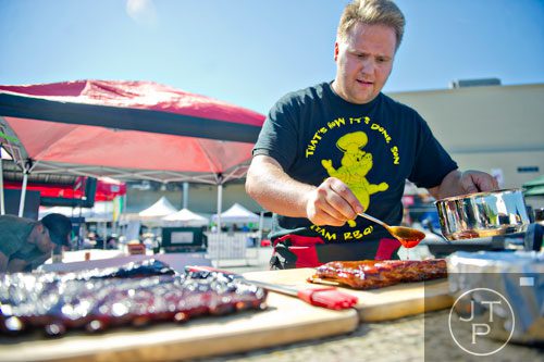 Randy Landfried with the That's How it's DONE Son team sauces a rack of spare ribs during the Atlanta Bar-B-Q Festival at Atlantic Station in Midtown on Saturday, September 14, 2013. 